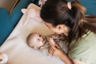 Jeune maman jouant avec son bébé à la maison